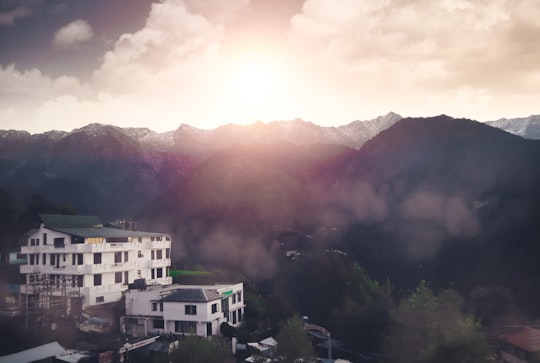 white and brown concrete building near green trees during daytime in Dalhousie India