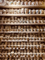 A collection of unique ceramic cups displayed on a shelf.