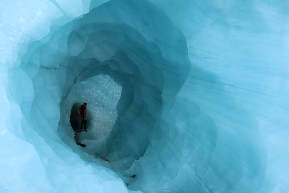 person in black jacket sitting on ice