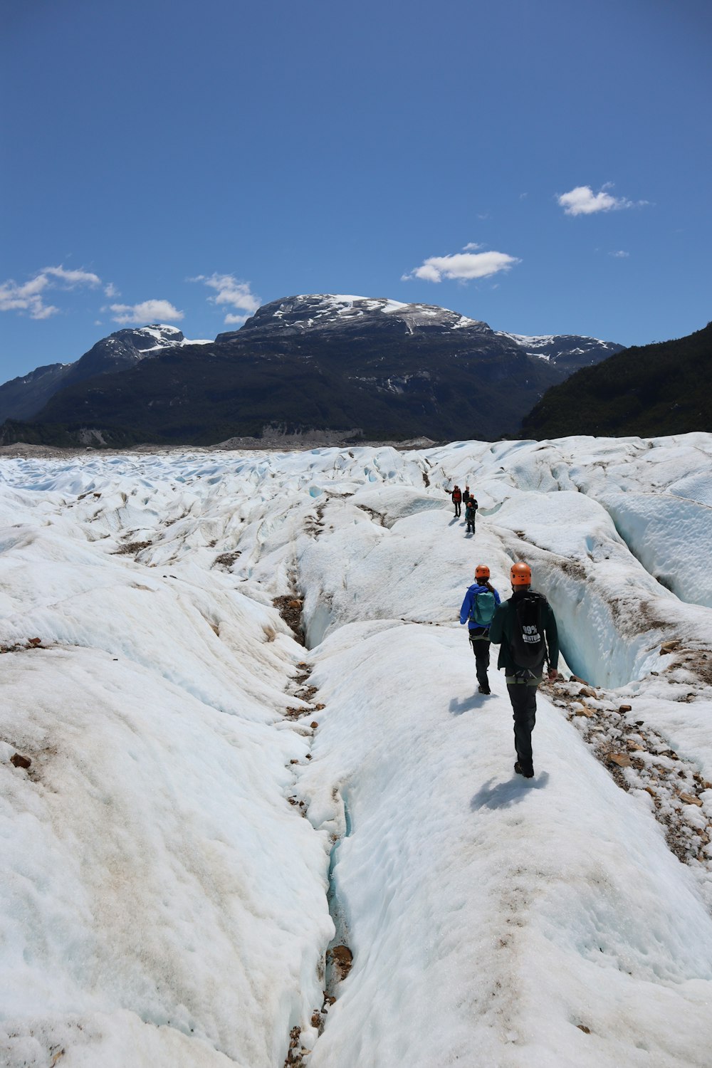 2 personas caminando en un campo cubierto de nieve durante el día