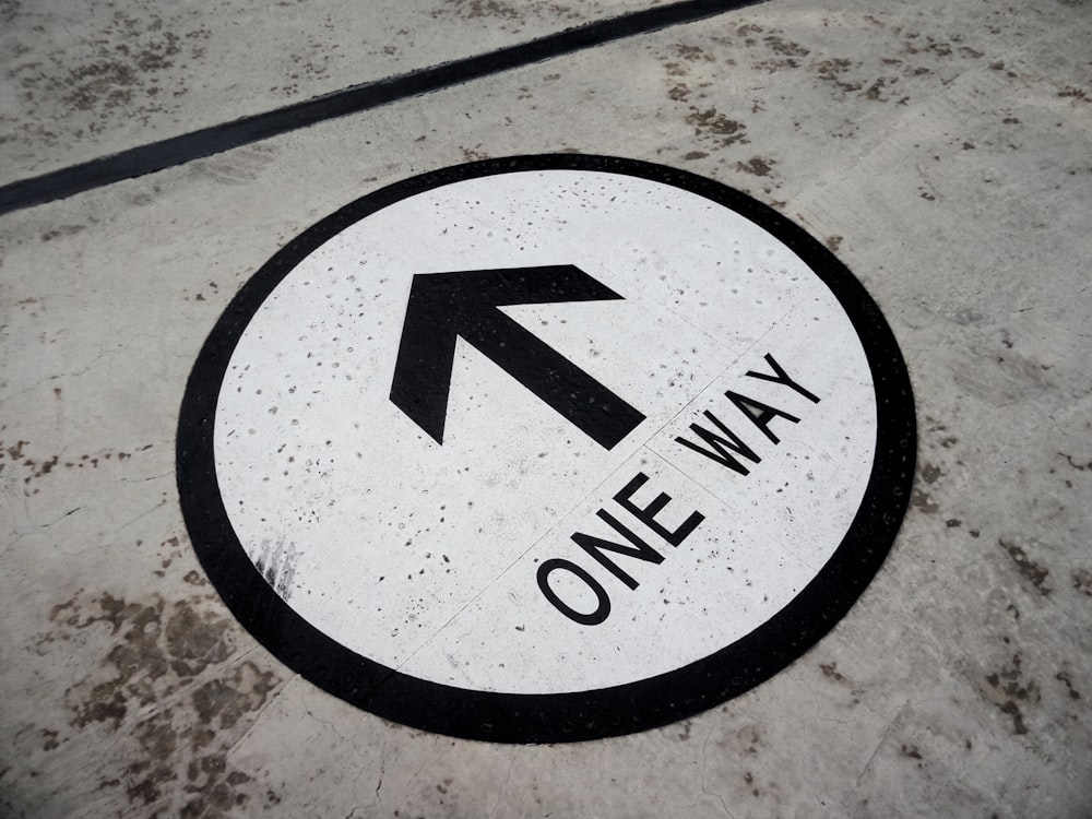 black and white round arrow sign