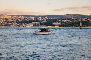 A close-up of a classic white sailboat cutting through gentle waves near Didim's shore