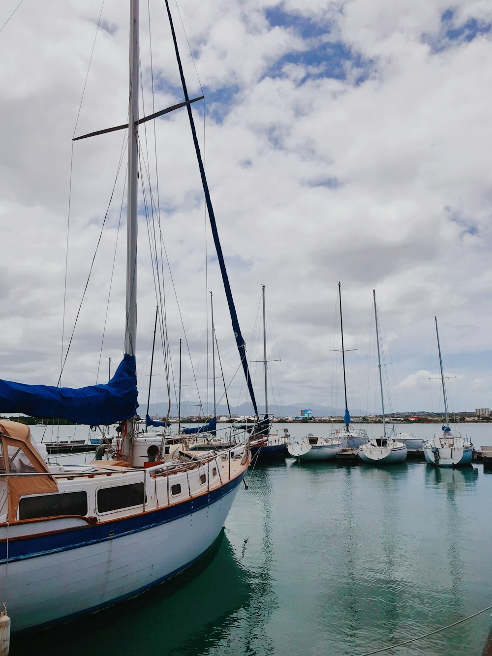 white and blue boat on sea under white clouds during daytime