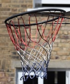 A close-up shot of a basketball with a net in the background.