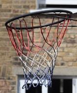 A close-up of a basketball hoop with a ball approaching.