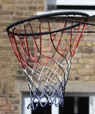 Close-up of a basketball hoop and ball during a game in a sports gym.