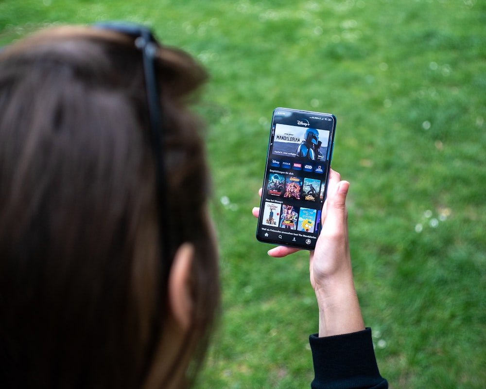 woman holding black android smartphone