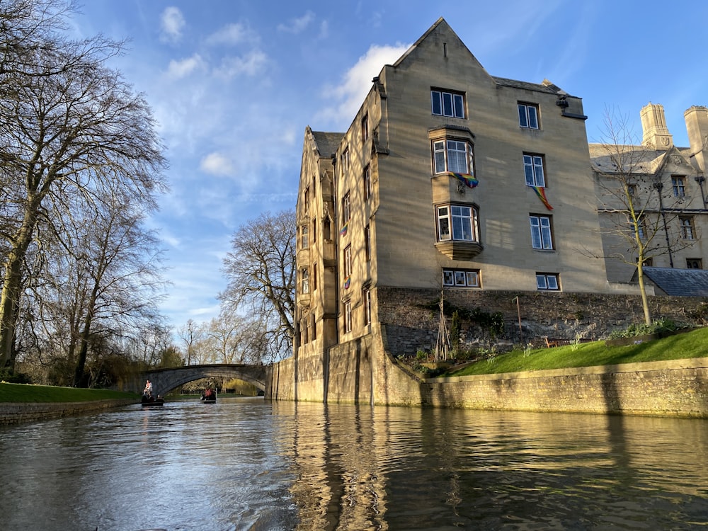 brown concrete building near river under blue sky during daytime