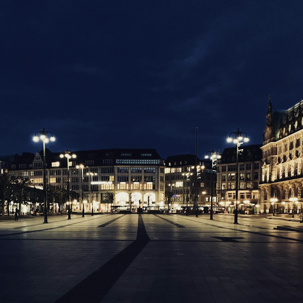 people walking on sidewalk near building during night time