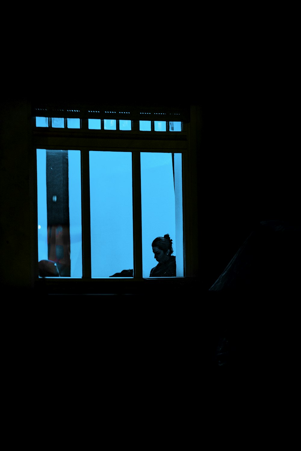 silhouette of man and woman standing in front of window during daytime
