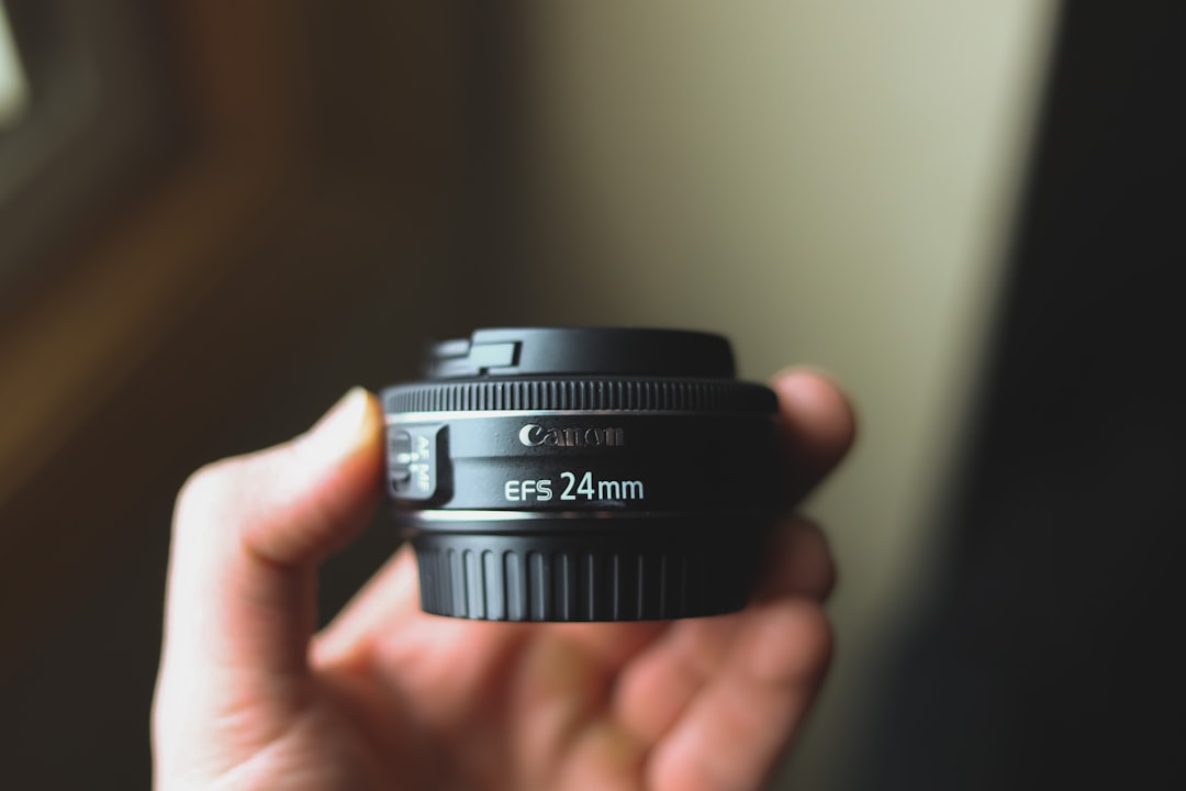 person holding black nikon camera lens