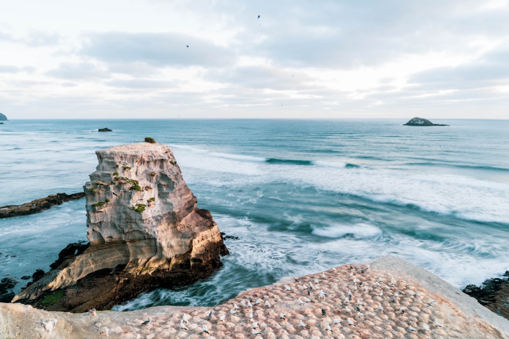 brown rock formation near body of water during daytime