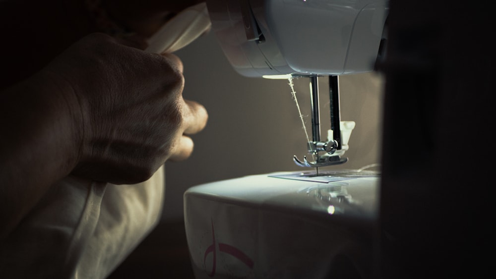 person holding white sewing machine