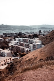 Modern hillside apartments with large windows overlooking terraced fields and distant mountains.