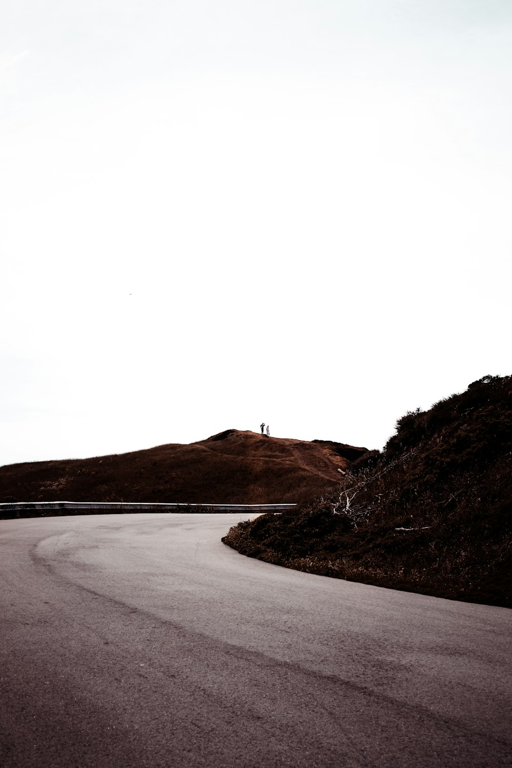 gray asphalt road near body of water during daytime