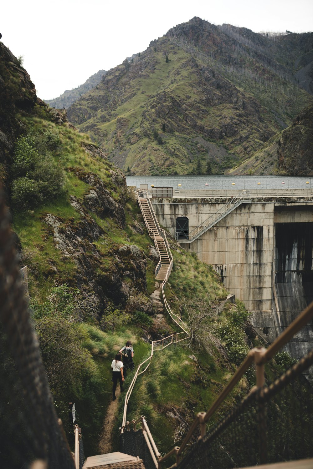 man in black jacket standing on brown wooden bridge during daytime