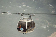 Travelers riding the Komagatake ropeway, gazing out over breathtaking mountain vistas and forests.