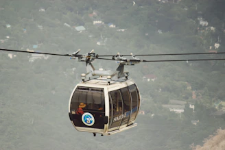 Travelers riding the Komagatake ropeway, gazing out over breathtaking mountain vistas and forests.