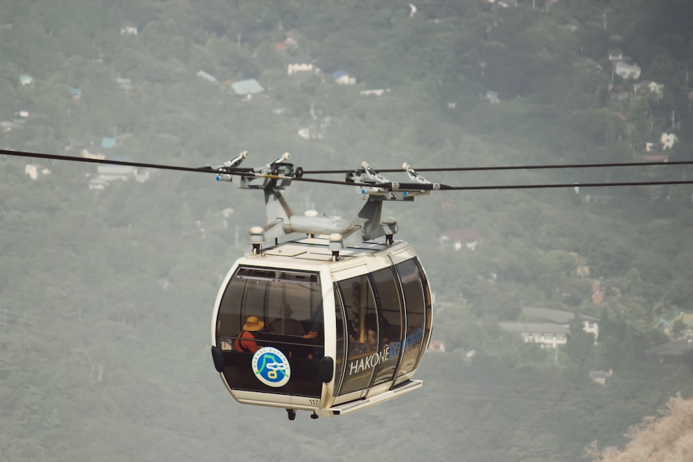 Weiße und schwarze Seilbahn tagsüber unter weißen Wolken