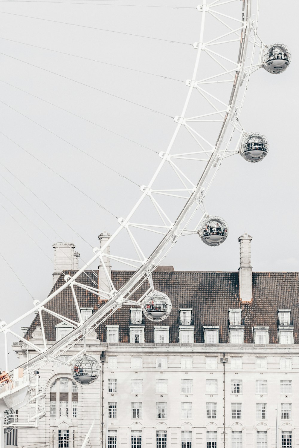 white ferris wheel near brown concrete building during daytime