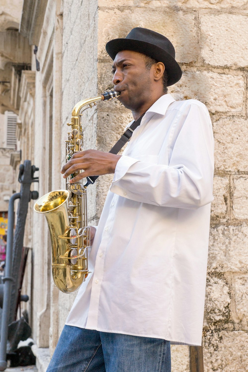 man in white dress shirt playing saxophone