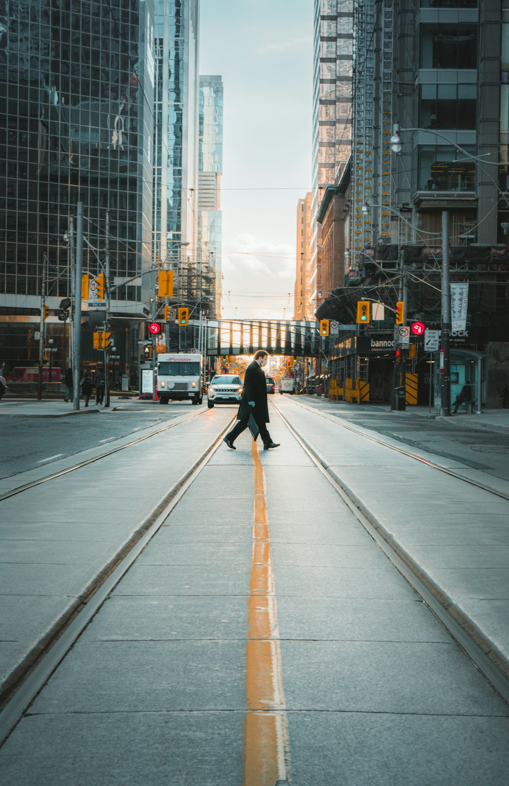 man in black jacket and black pants walking on sidewalk during daytime