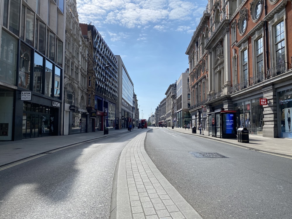 gray concrete road between buildings under blue sky during daytime