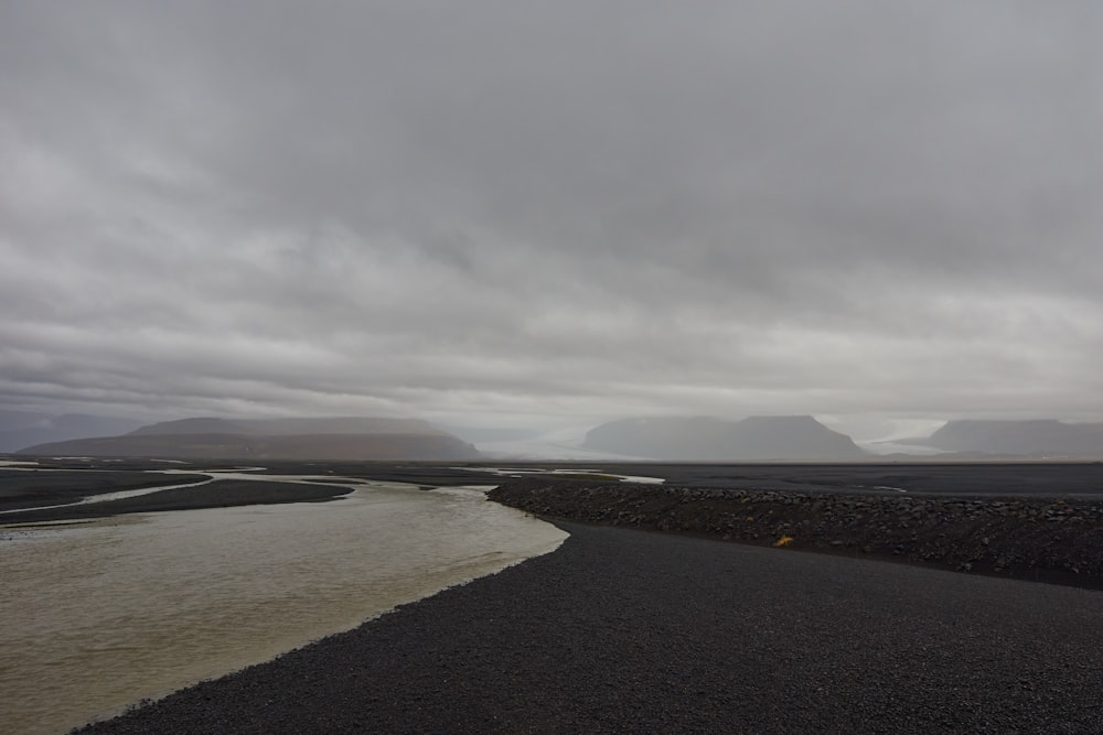 route goudronnée grise sous ciel gris