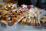Close-up of assorted freshly baked cakes stacked neatly on delivery trays.