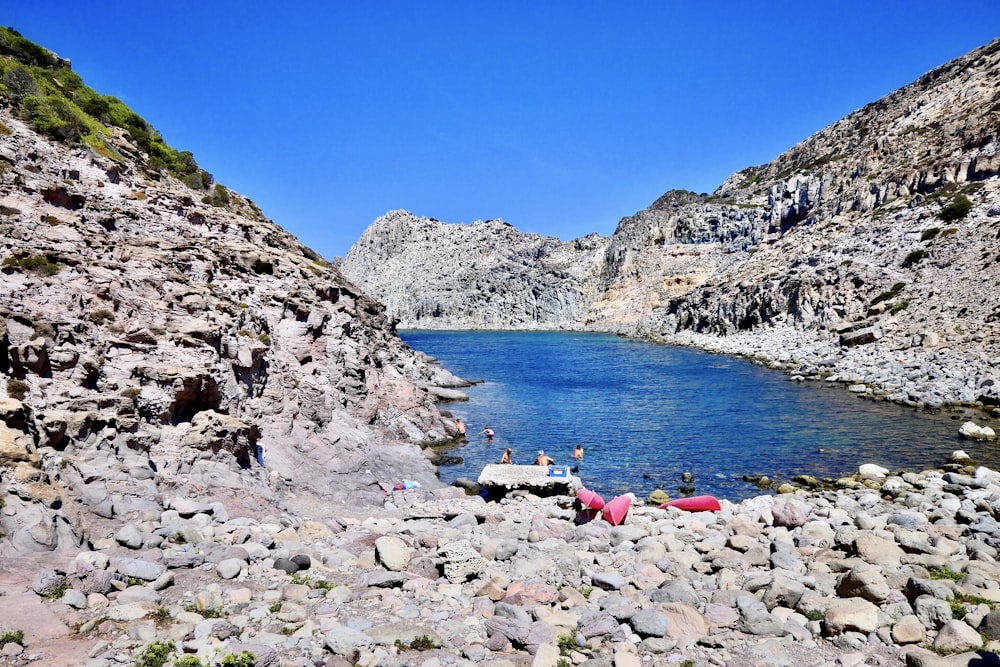 people sitting on rocky shore during daytime