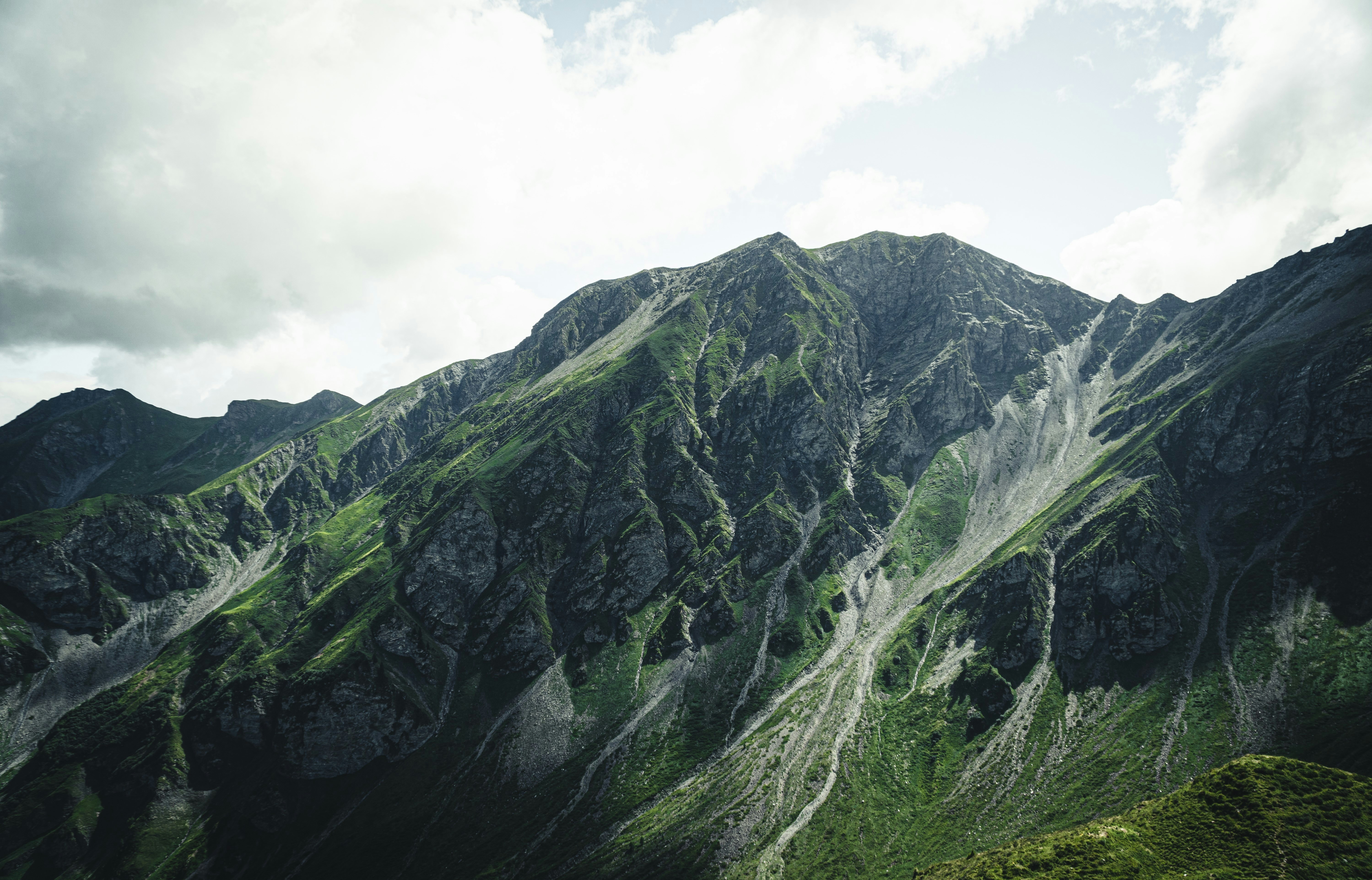 Green and gray mountain under white clouds during daytime photo Free