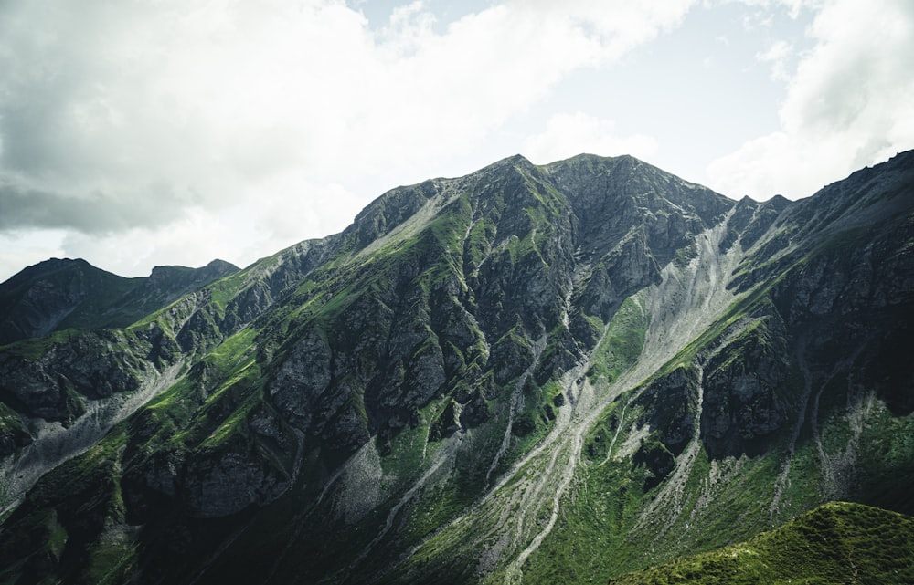 green and gray mountain under white clouds during daytime