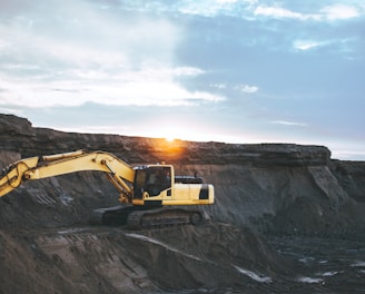 yellow and white excavator on rocky mountain during daytime