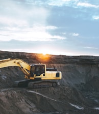 yellow and white excavator on rocky mountain during daytime