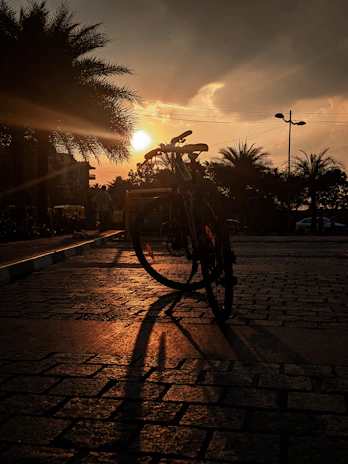 Sunset glow casting long shadows on a rental bike parked near white marble quarries of the area.