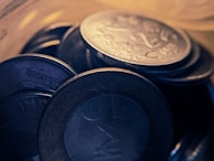 Close-up of shiny collectible coins arranged in a neat circle on a white background