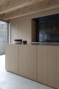 brown wooden cabinet near window