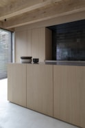 brown wooden cabinet near window