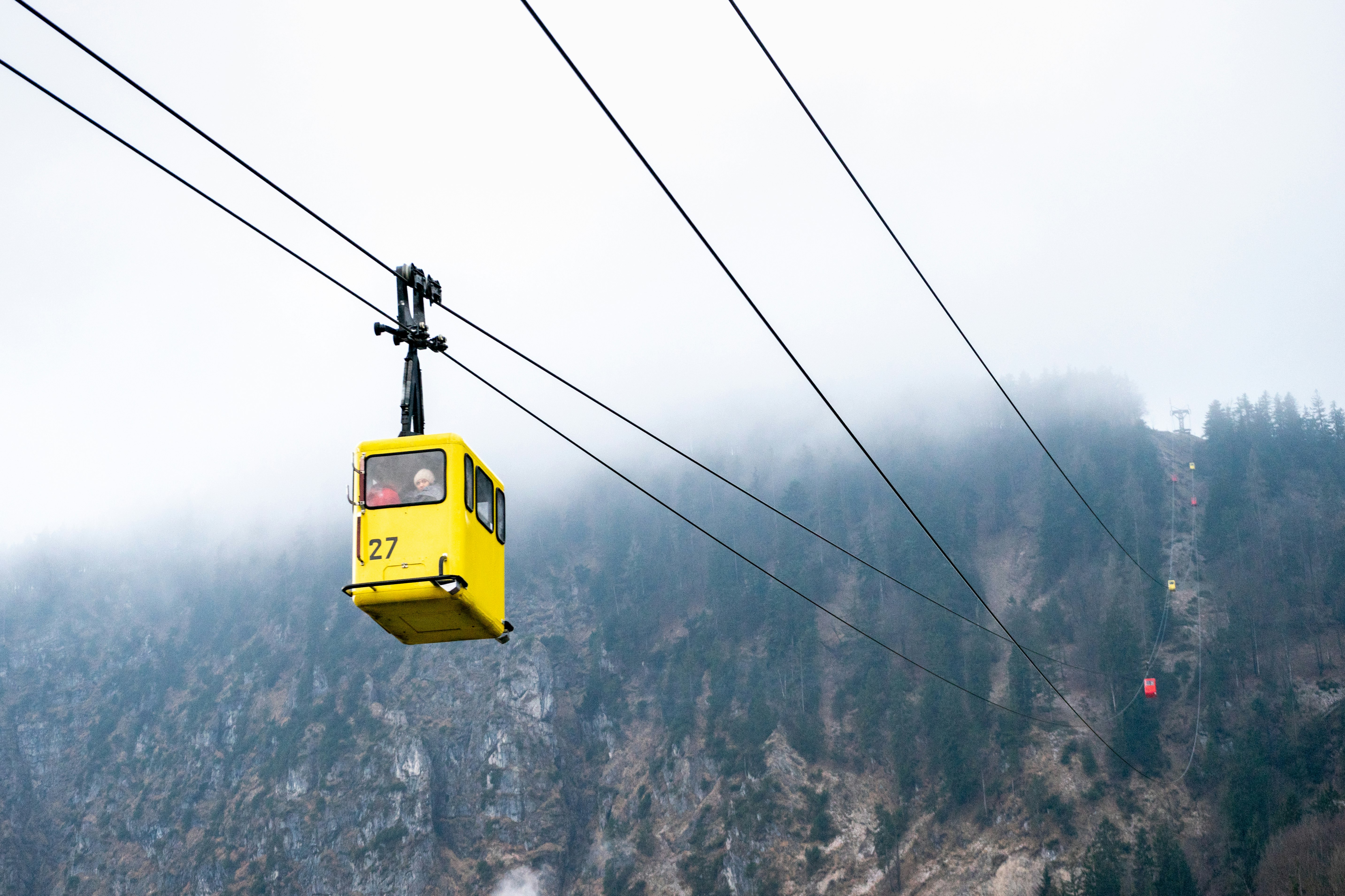 yellow cable car over snow covered mountain