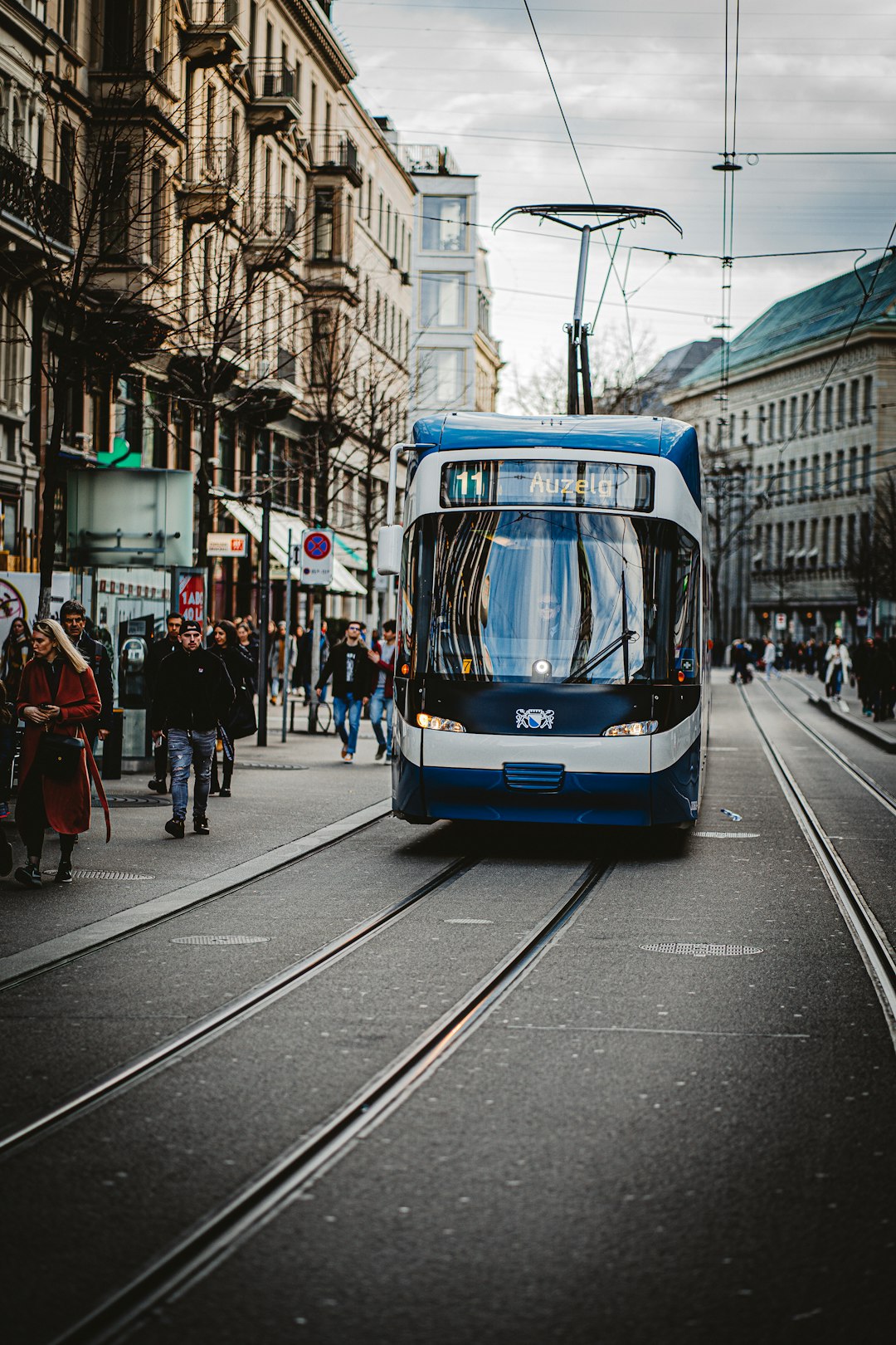 people riding on blue and white tram during daytime