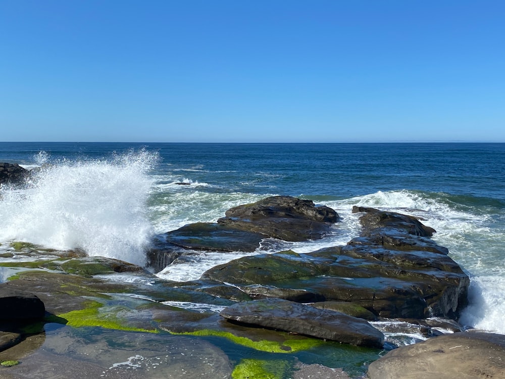 Las olas del mar rompiendo contra las rocas durante el día