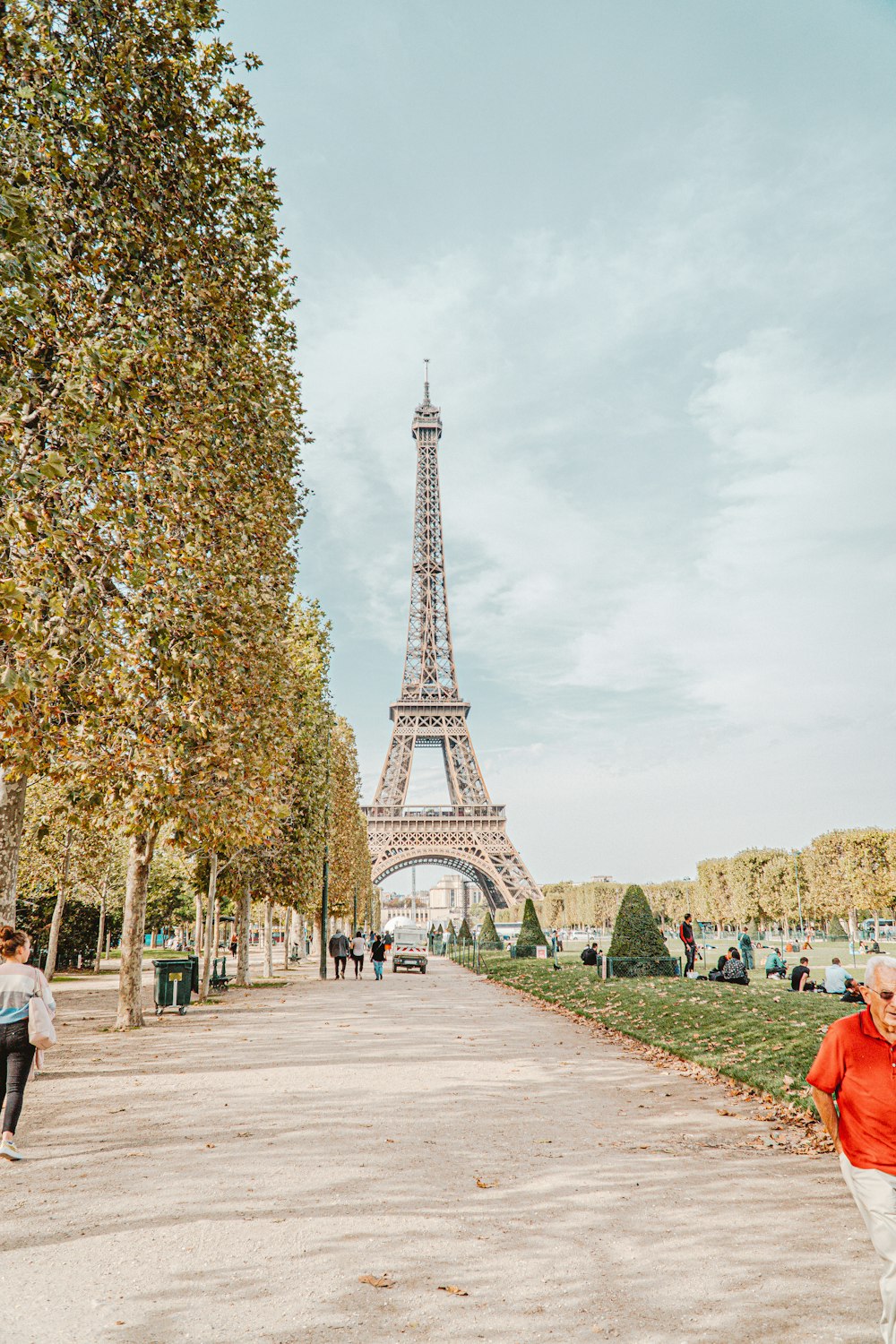 Persone che camminano sul marciapiede vicino alla Torre Eiffel durante il giorno