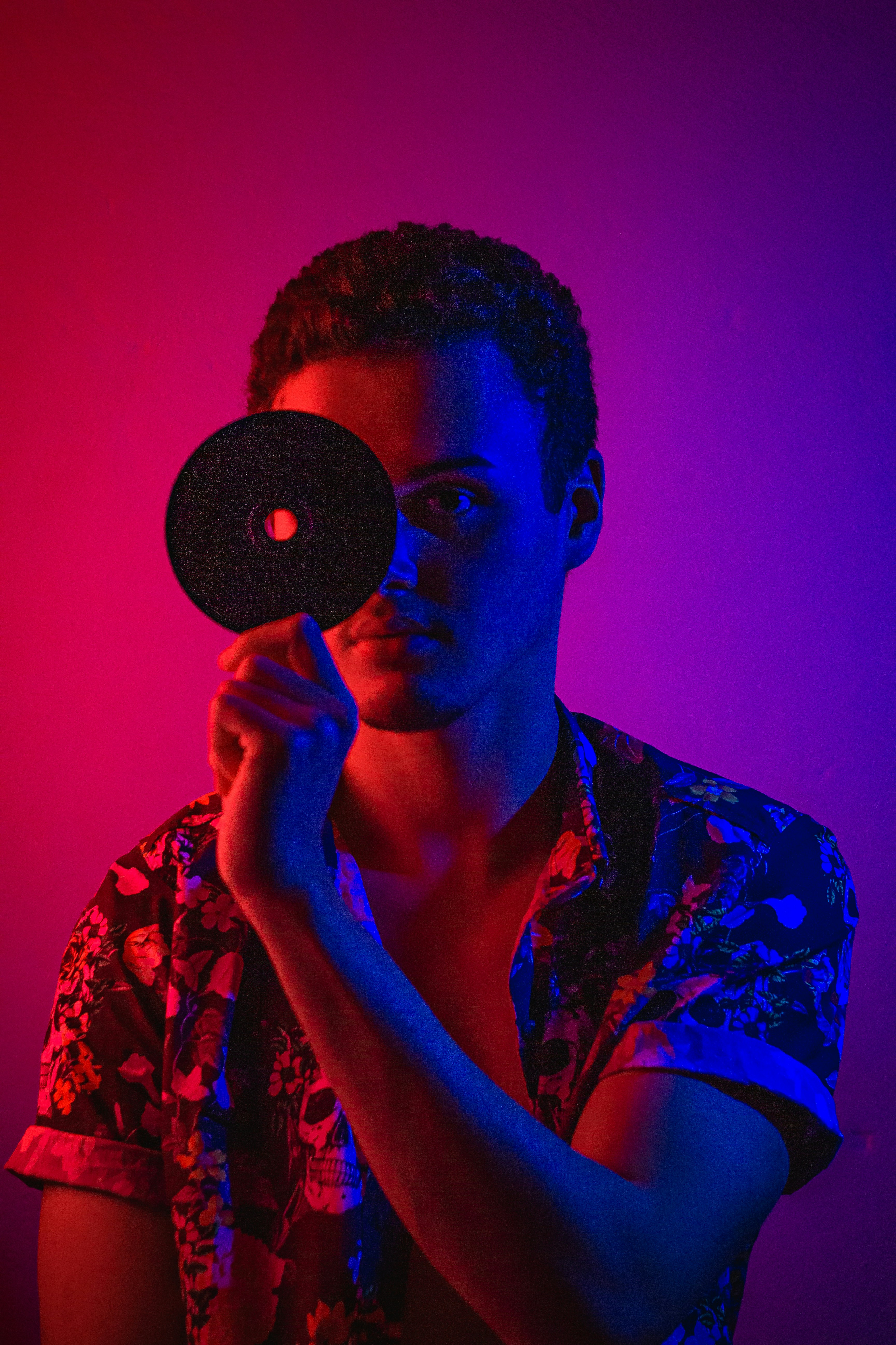 man in black and white floral shirt holding round black ornament