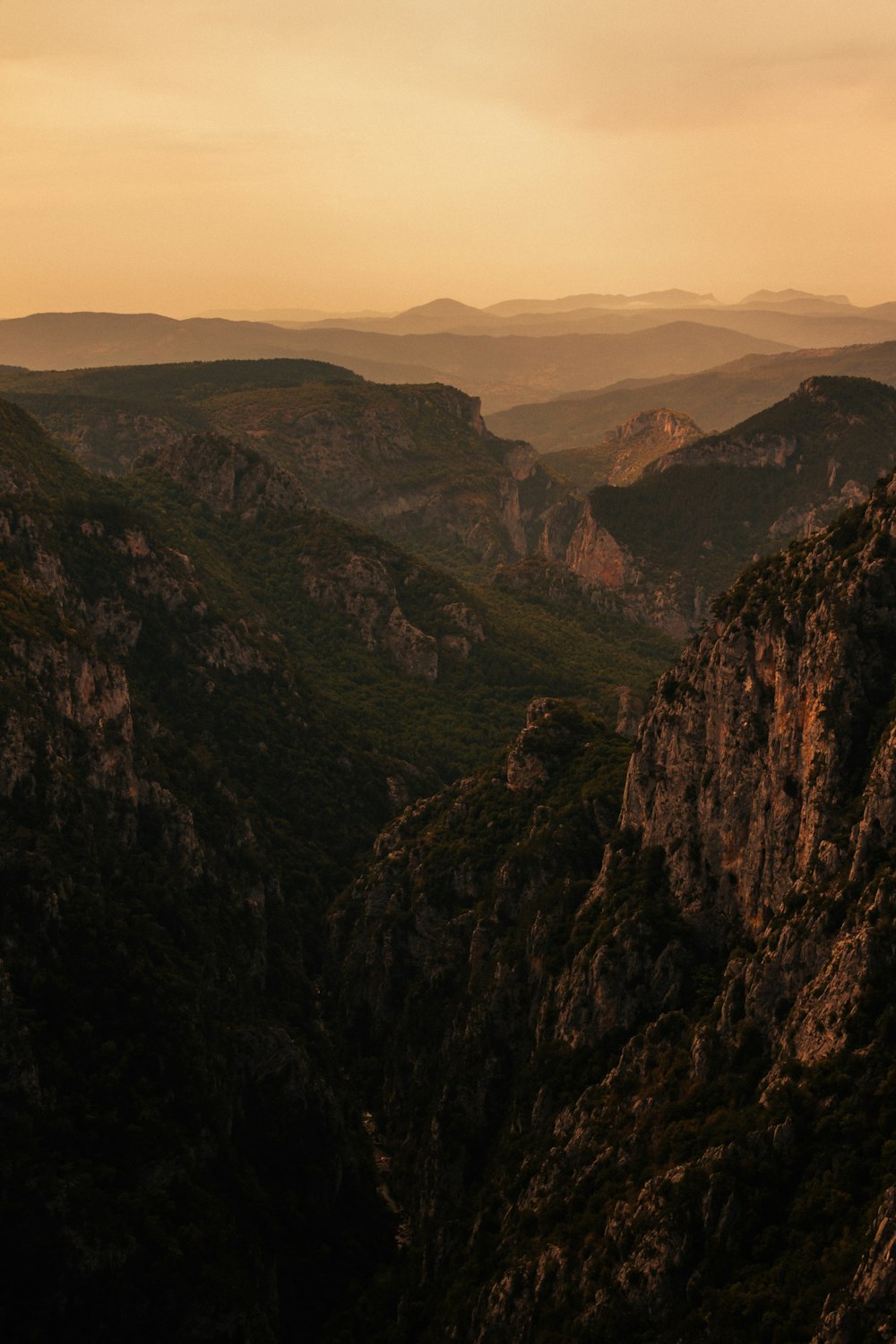 Montañas marrones y verdes bajo el cielo blanco durante el día