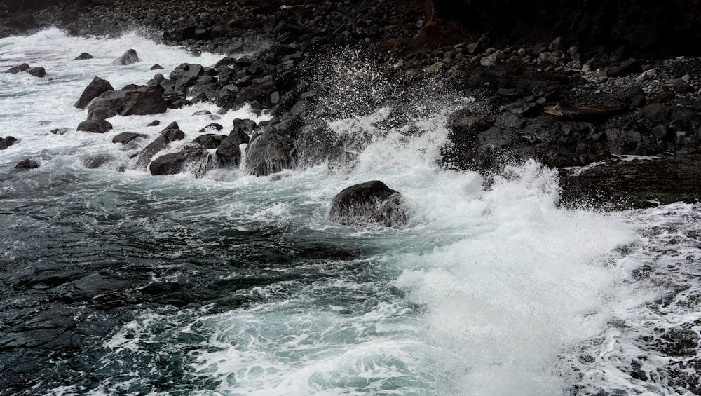 body of water near brown rock formation during daytime