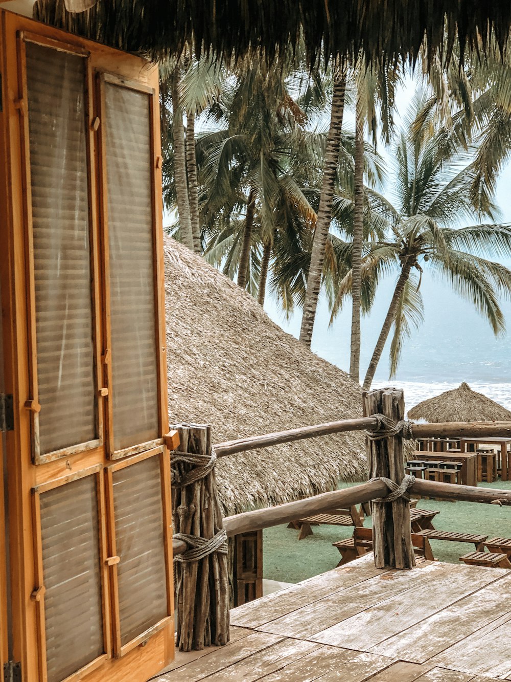 brown wooden house near green palm tree during daytime