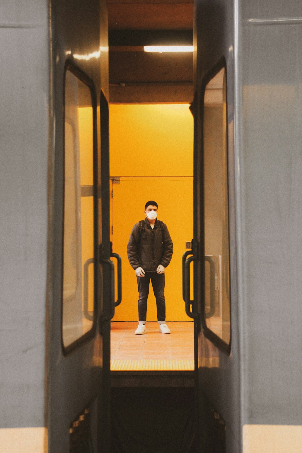 man in black jacket standing in front of mirror