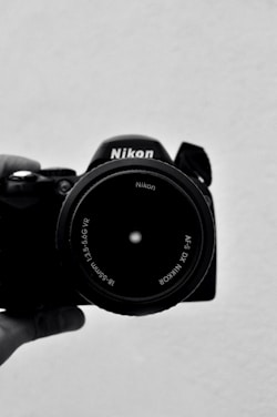 black nikon dslr camera on white table