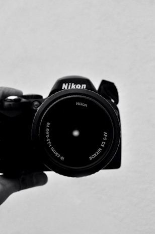 black nikon dslr camera on white table