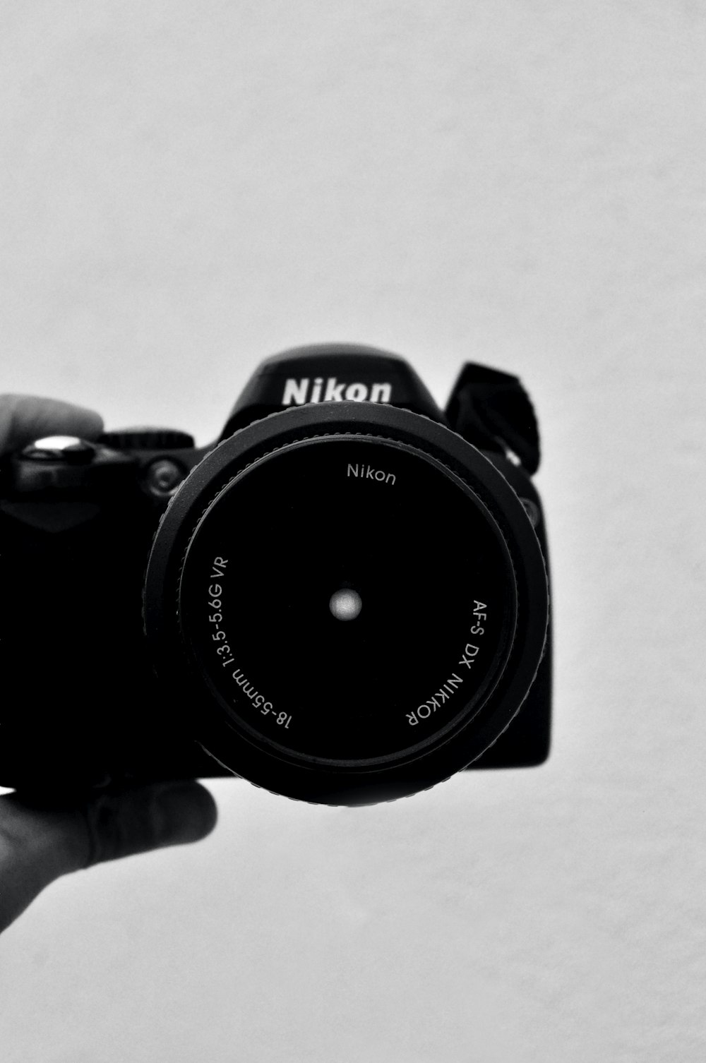 black nikon dslr camera on white table